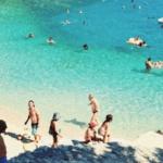 People enjoying swimming and relaxing at Emplisi Beach in Fiskardo, Kefalonia.