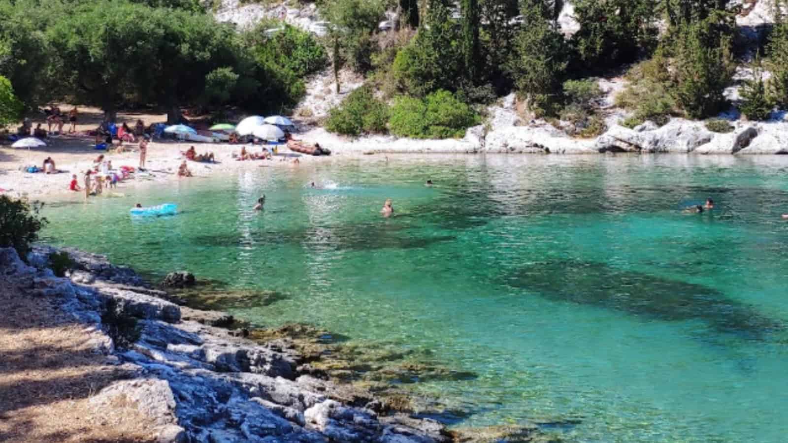 Foki Beach with clear turquoise waters and visitors enjoying the seaside.