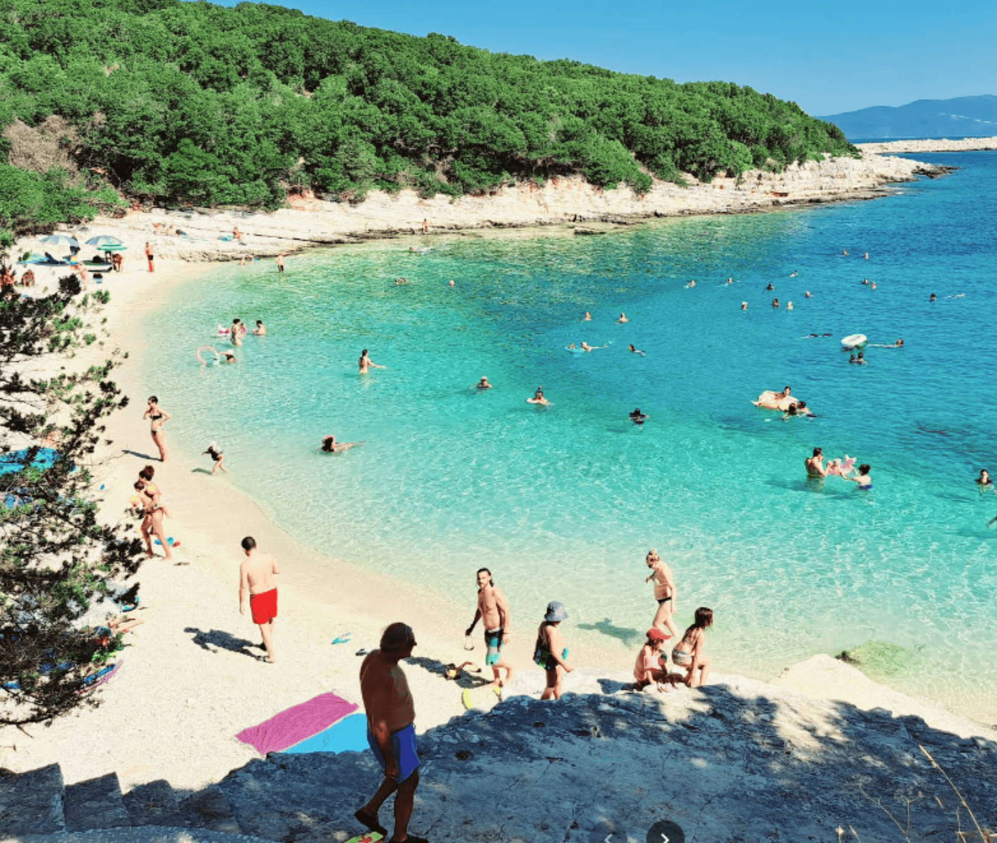 Beautiful view of Emplisi Beach with clear turquoise waters and lush green surroundings.